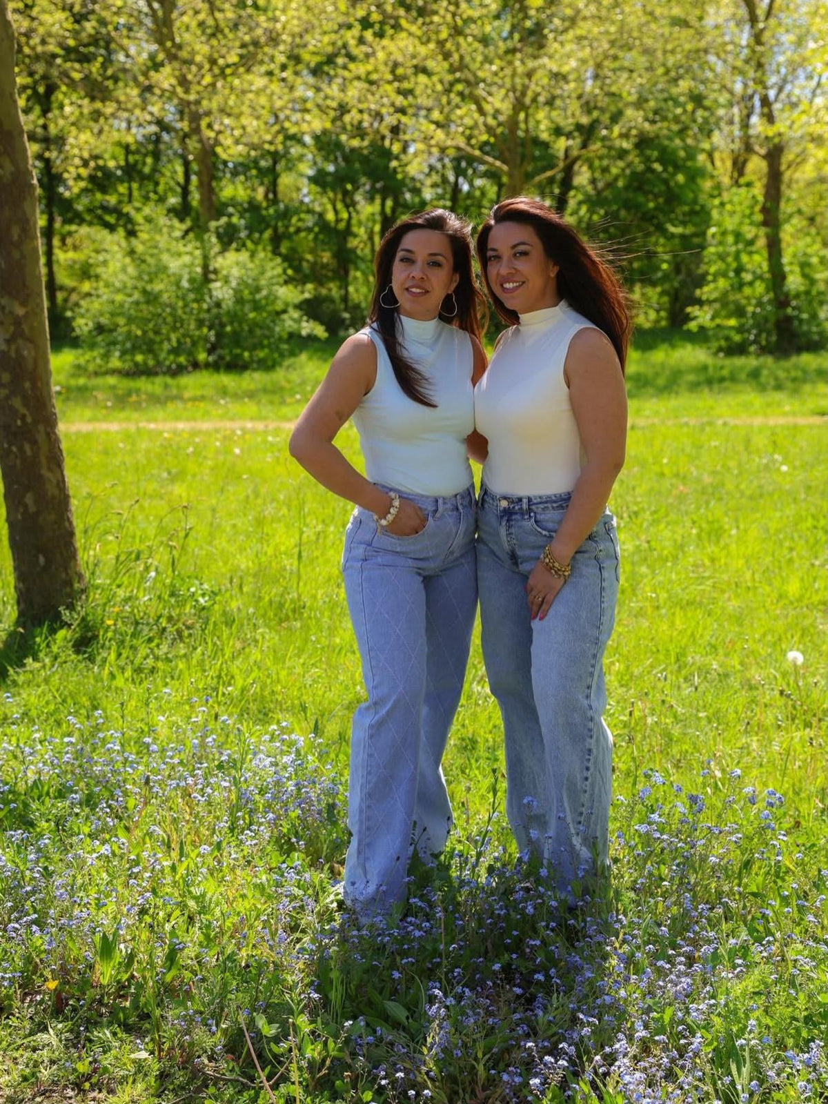 Anouk en Aimee in jeans en witte top in het park