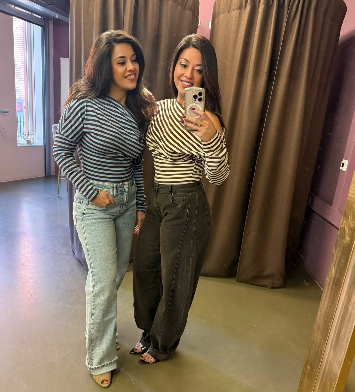 Anouk en Aimee in gestreepte tops in de paskamer van de winkel